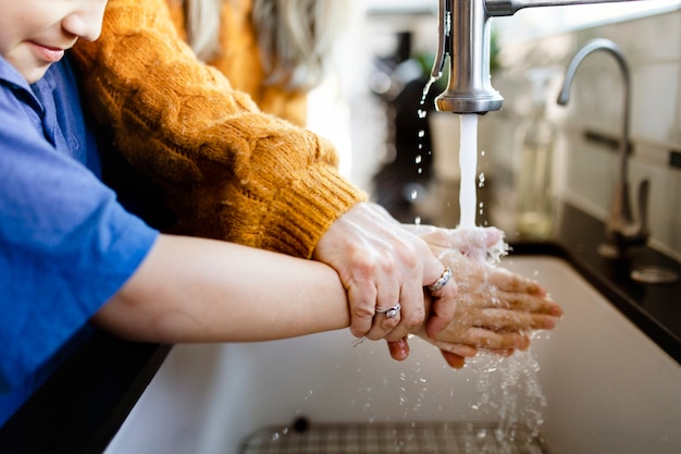 Niño lavándose las manos en el fregadero