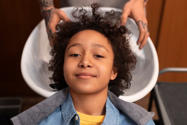 Niño lavándose el pelo en el salón