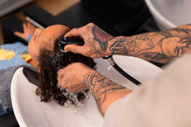 Niño lavándose el pelo en el salón