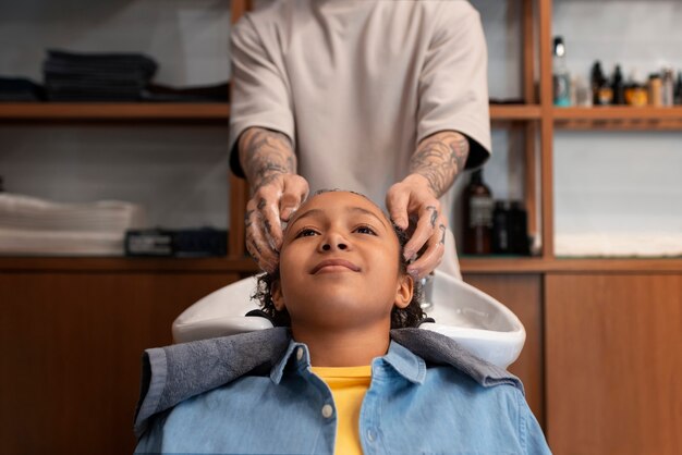 Niño lavándose el pelo en el salón