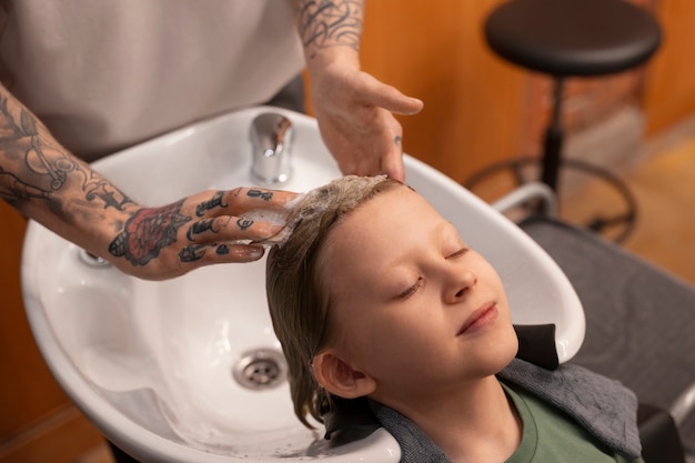 Foto gratuita niño lavándose el pelo en el salón