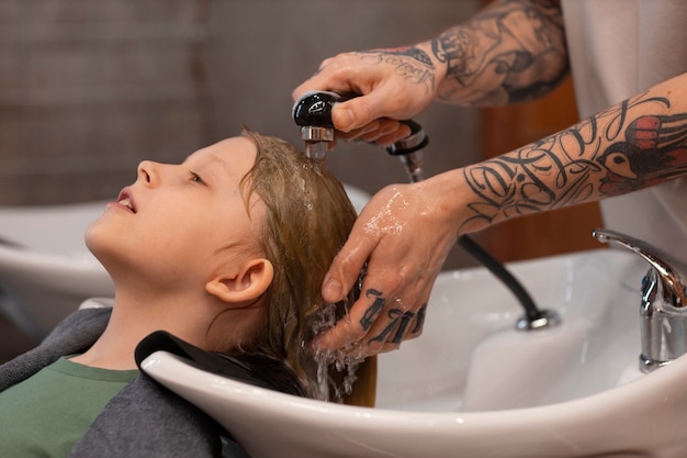 Niño lavándose el pelo en el salón