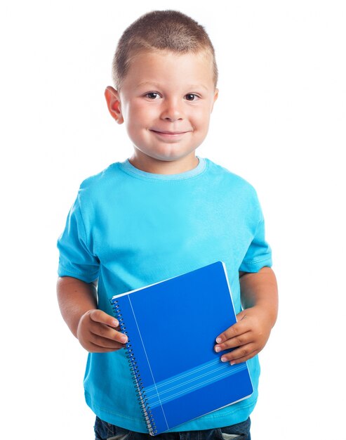 Niño con una libreta azul pequeña