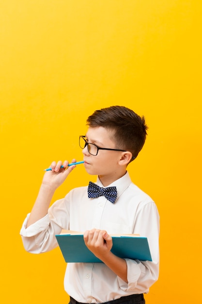 Foto gratuita niño con libro con espacio de copia