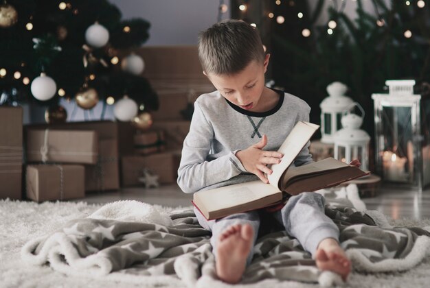 Niño con un libro mágico en el piso