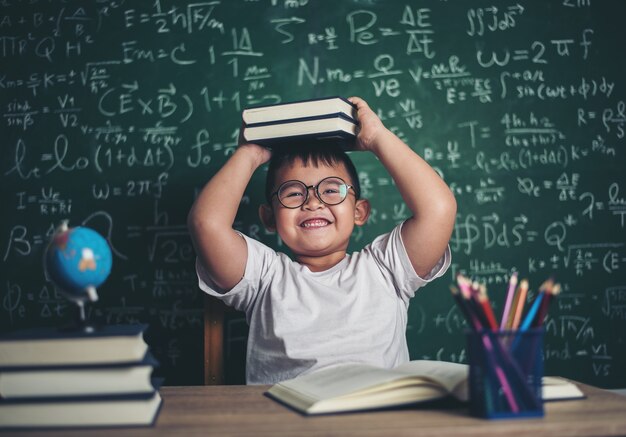 niño con libros sentados en el aula