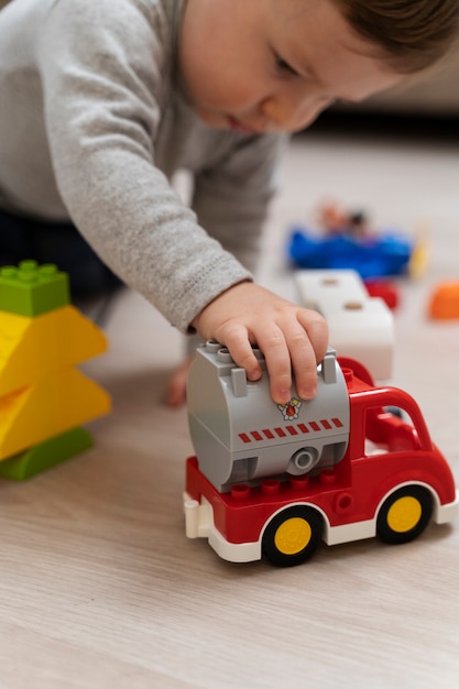 Niño lindo de alto ángulo jugando con coche