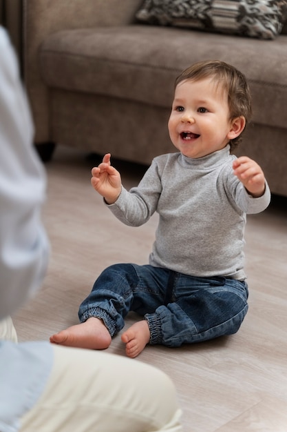 Foto gratuita niño lindo de alto ángulo sentado en el piso