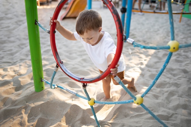 Foto gratuita niño lindo pagando en el patio de recreo