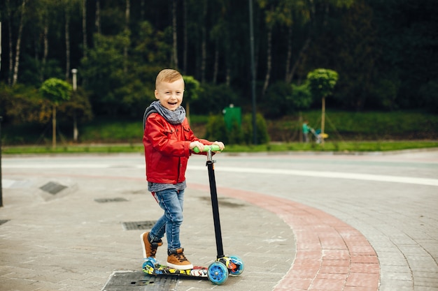 Niño lindo en un parque jugando en un césped