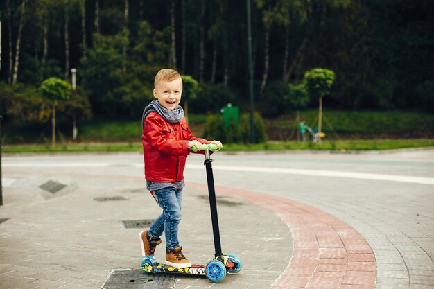 Niño lindo en un parque jugando en un césped