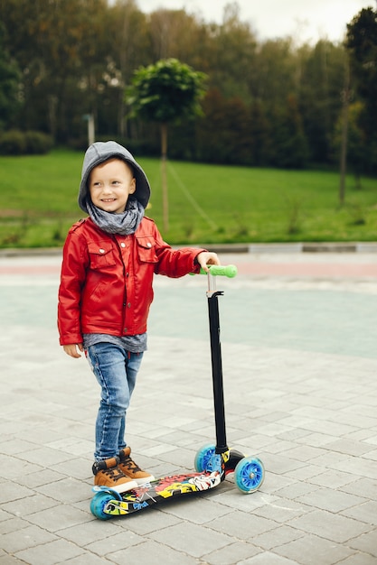 Niño lindo en un parque jugando en un césped