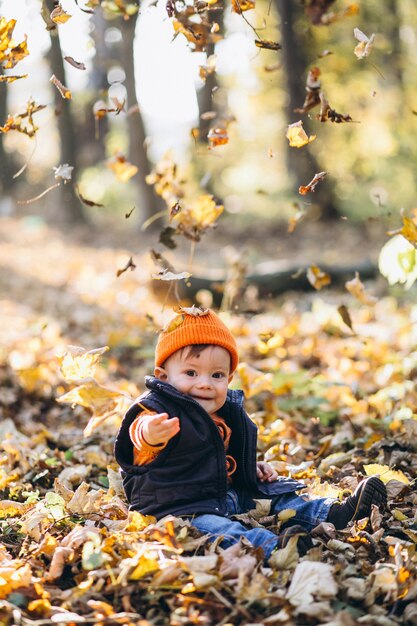 Niño lindo en un parque de otoño