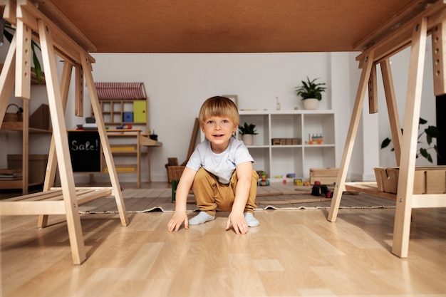 Foto gratuita niño lindo sonriente de tiro completo en casa