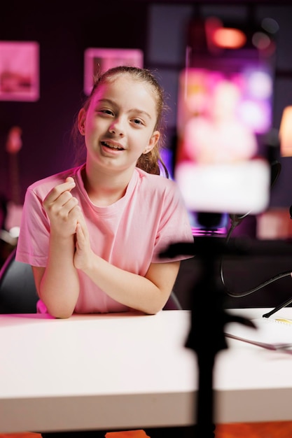 Foto gratuita un niño lindo transmite en vivo usando la cámara de un teléfono móvil para hablar con la audiencia en línea