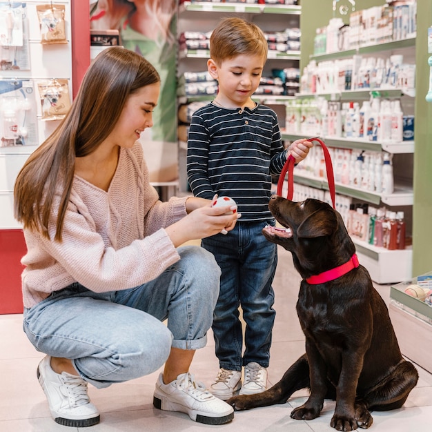 Niño y madre en la tienda de mascotas con su perro.