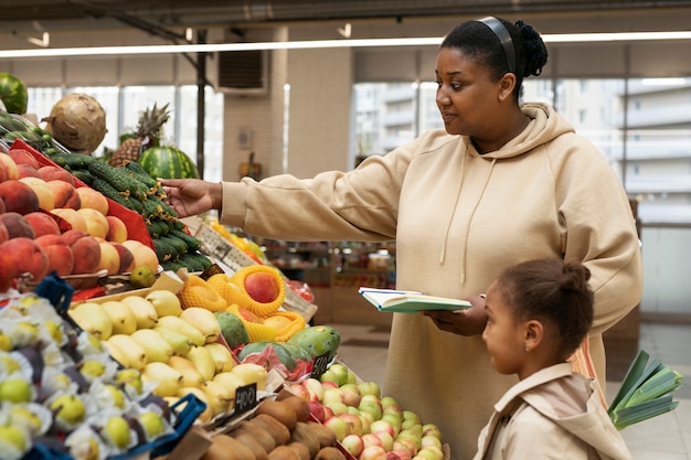 Niño y madre de tiro medio de compras