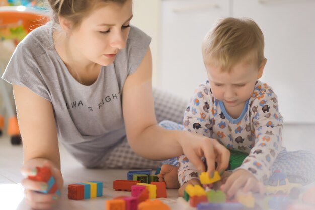 niño con mamá jugando en colorido kit de construcción