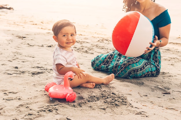 Niño con mamá jugando en la playa