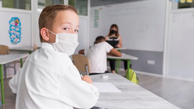 Niño con una mascarilla en el aula