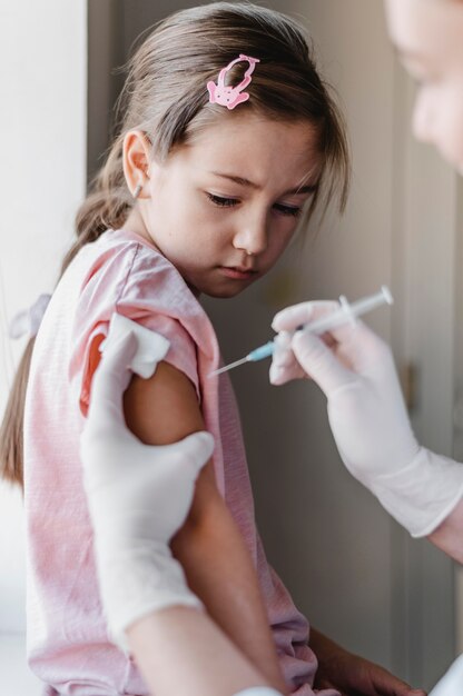 Niño con médico recibiendo una vacuna