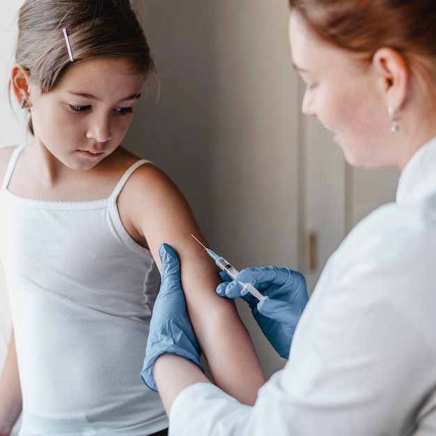 Niño en el médico recibiendo una vacuna.