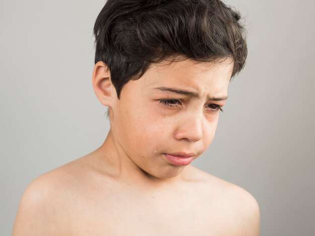 Niño mirando hacia abajo y molesto