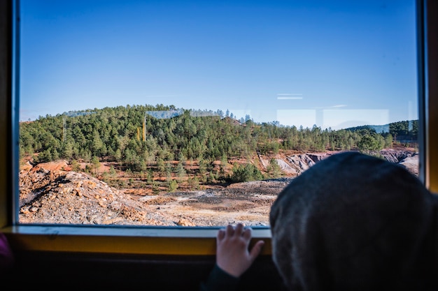 Foto gratuita niño mirando la naturaleza desde el tren