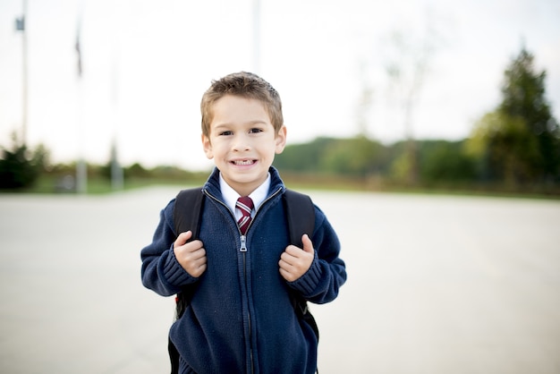 Foto gratuita niño con una mochila detrás