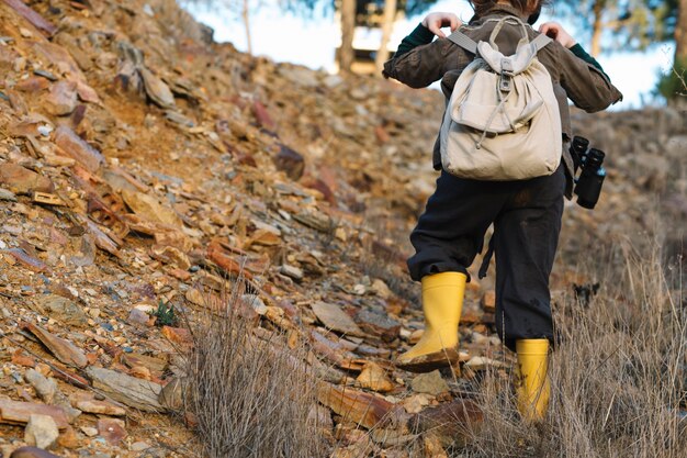 Niño con mochila escalada en la colina