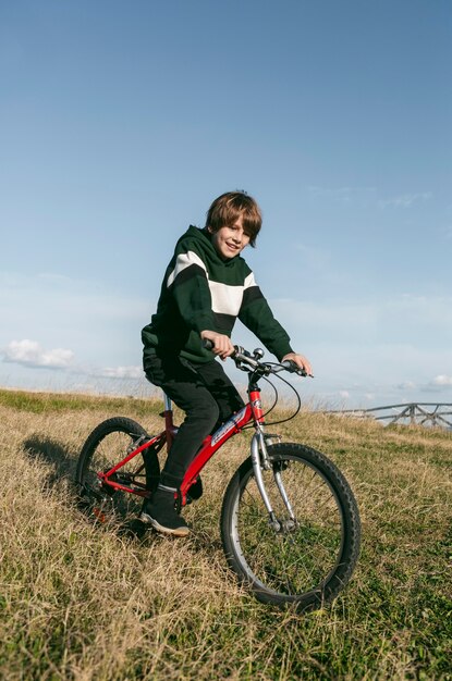 Niño montando su bicicleta sobre el césped al aire libre