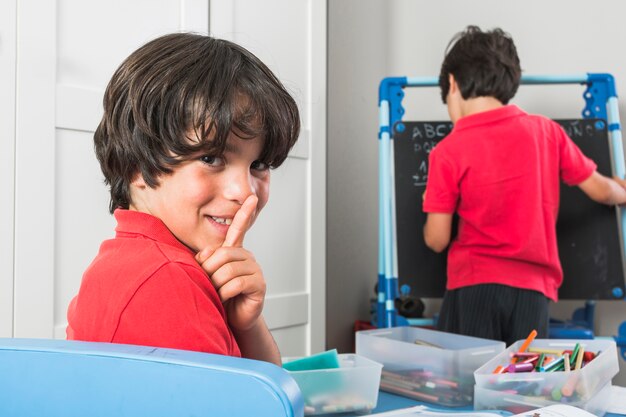 Niño mostrando gesto de silencio