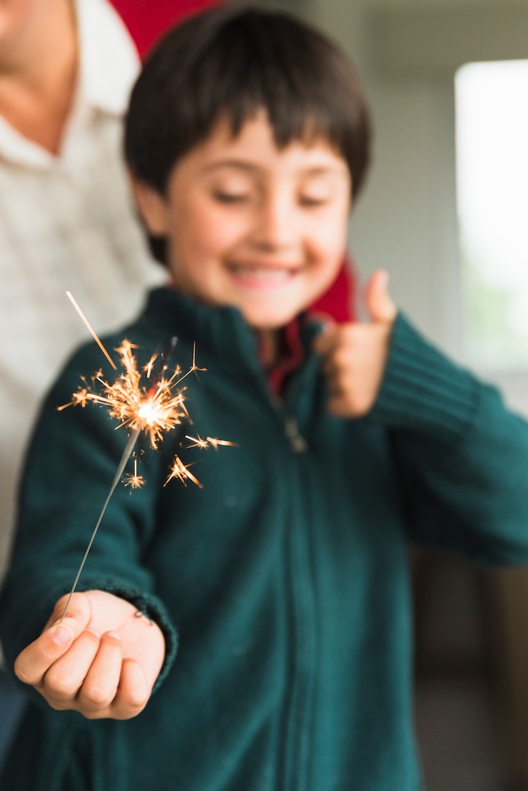 Foto gratuito niño mostrando luz de bengala cerca de humano