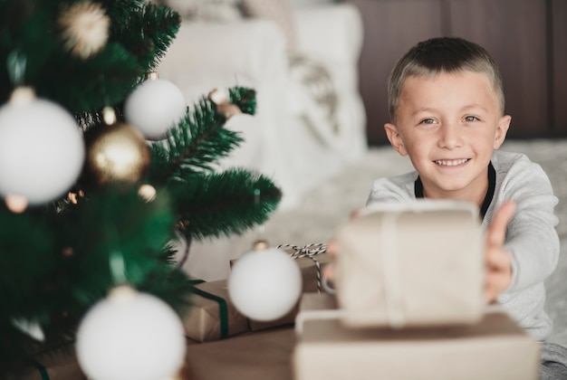 Niño mostrando un regalo de Navidad a la cámara