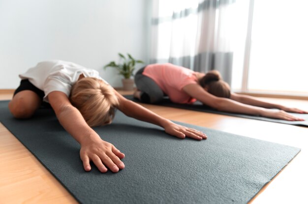 Niño y mujer con colchonetas de yoga full shot