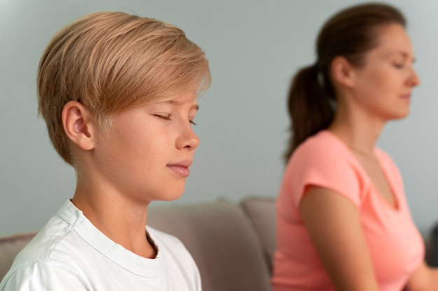 Niño y mujer meditando de cerca