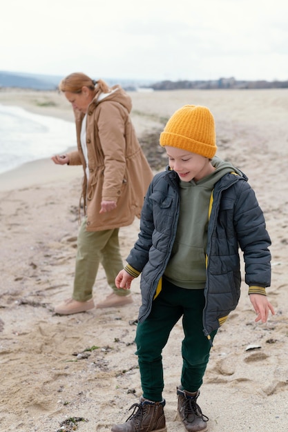 Niño y mujer, en, playa, tiro completo