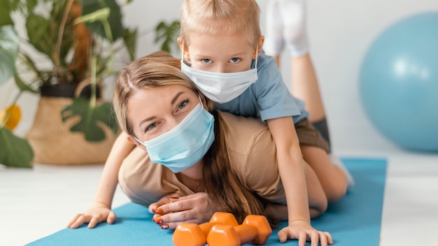 Niño y mujer de tiro completo con máscaras