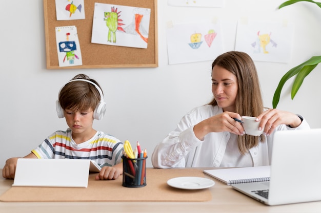 Niño y mujer de tiro medio con dispositivos.