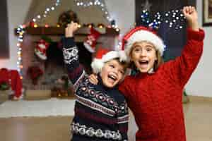 Foto gratuita niño y niña celebrando con un brazo levantado