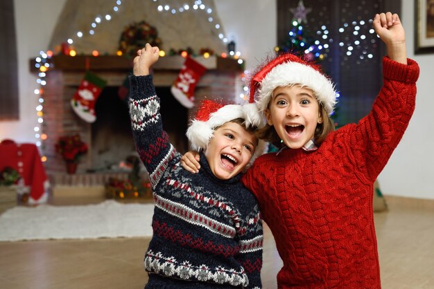 Niño y niña celebrando con un brazo levantado