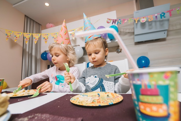 Niño y niña comiendo pastel de cumpleaños