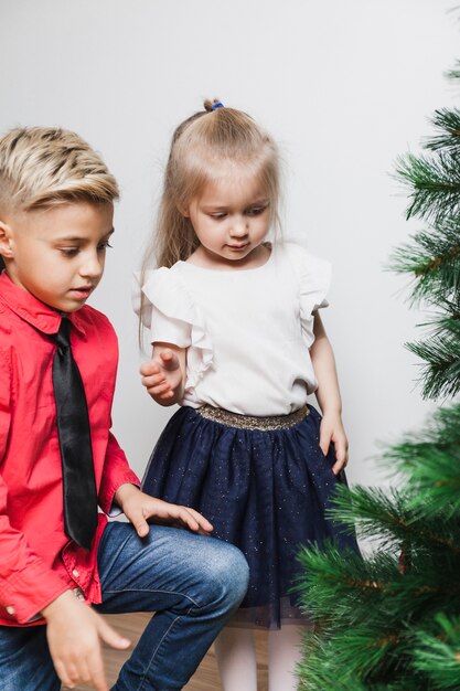 Niño y niña decorando árbol de navidad