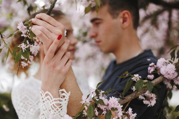 Niño y niña se encuentran cara a cara bajo el árbol de primavera en flor