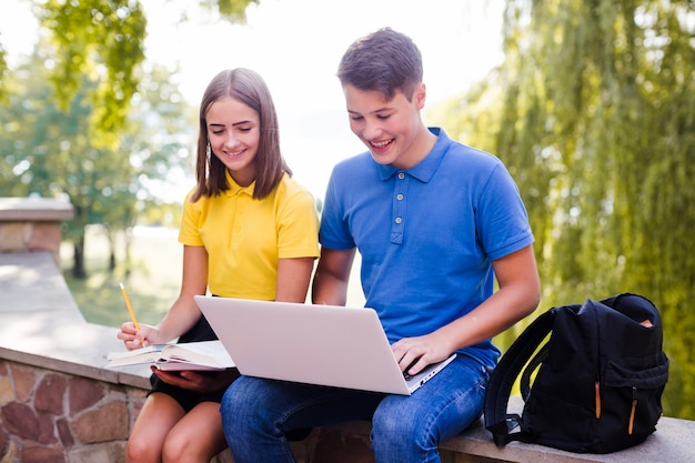 Niño con niña estudiando en la naturaleza