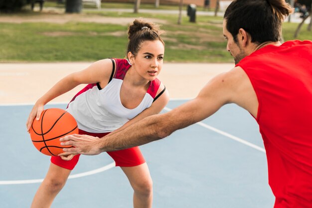 Niño y niña jugando baloncesto