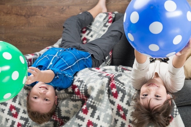 Niño y niña jugando con globos