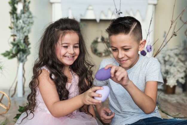 Niño y niña jugando con huevos de pascua