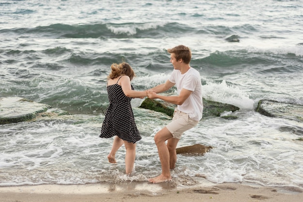 Niño y niña jugando juntos en el mar