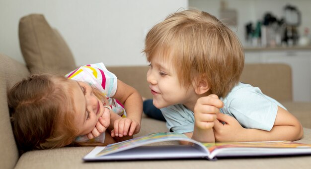 Niño y niña leyendo en casa